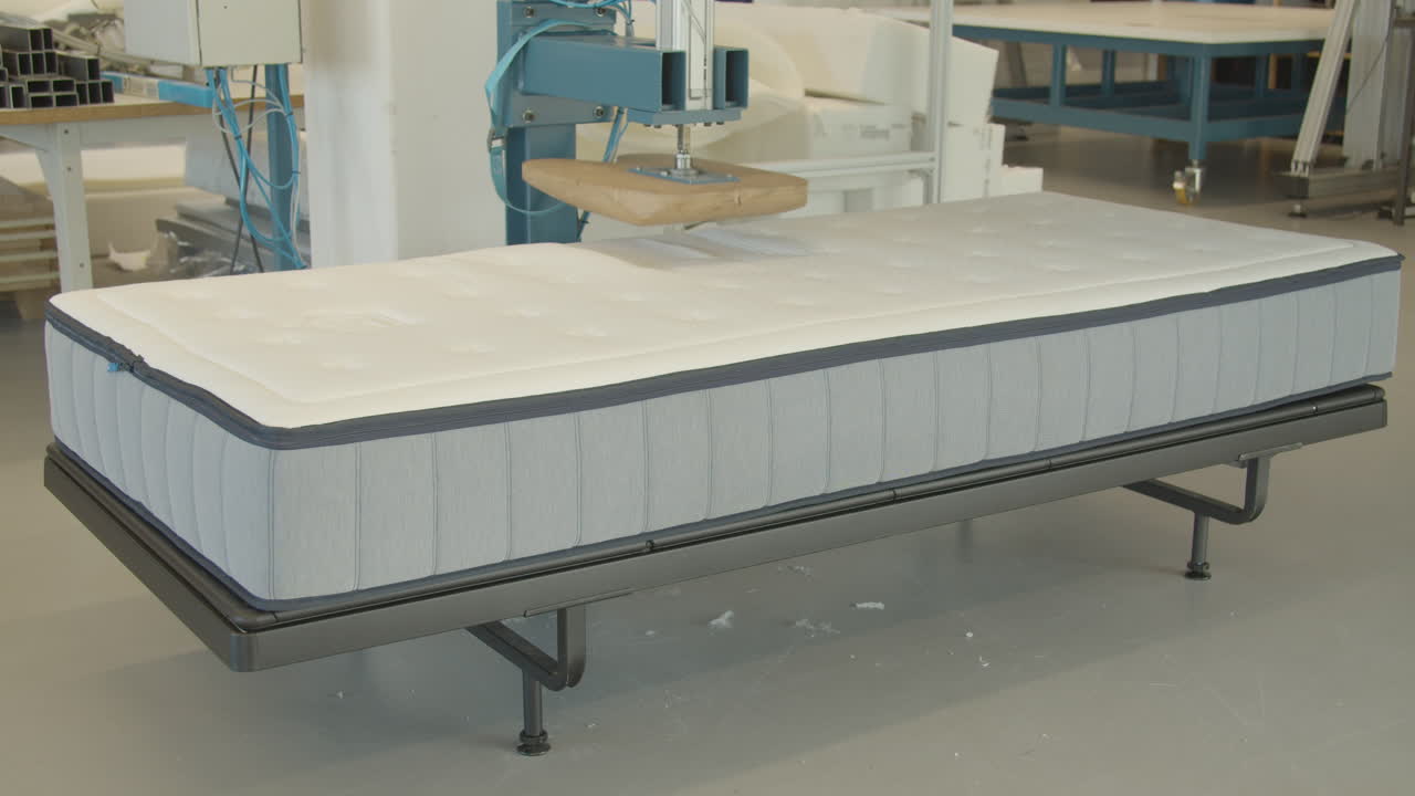 prensa de madera en forma de tope que prueba la calidad de un colchón nuevo en una instalación de prueba - ancho