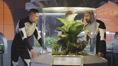 astronaut in space suit standing in front of a plant in a greenhouse