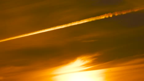 Acercamiento-Lento-Al-Cielo-Del-Atardecer-De-La-Hora-Dorada-De-Color-Amarillo-Intenso-Con-Una-Línea-De-Estelas-De-Avión