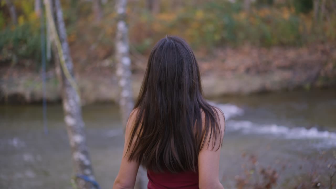 a woman while on a run stopped by a riverside.