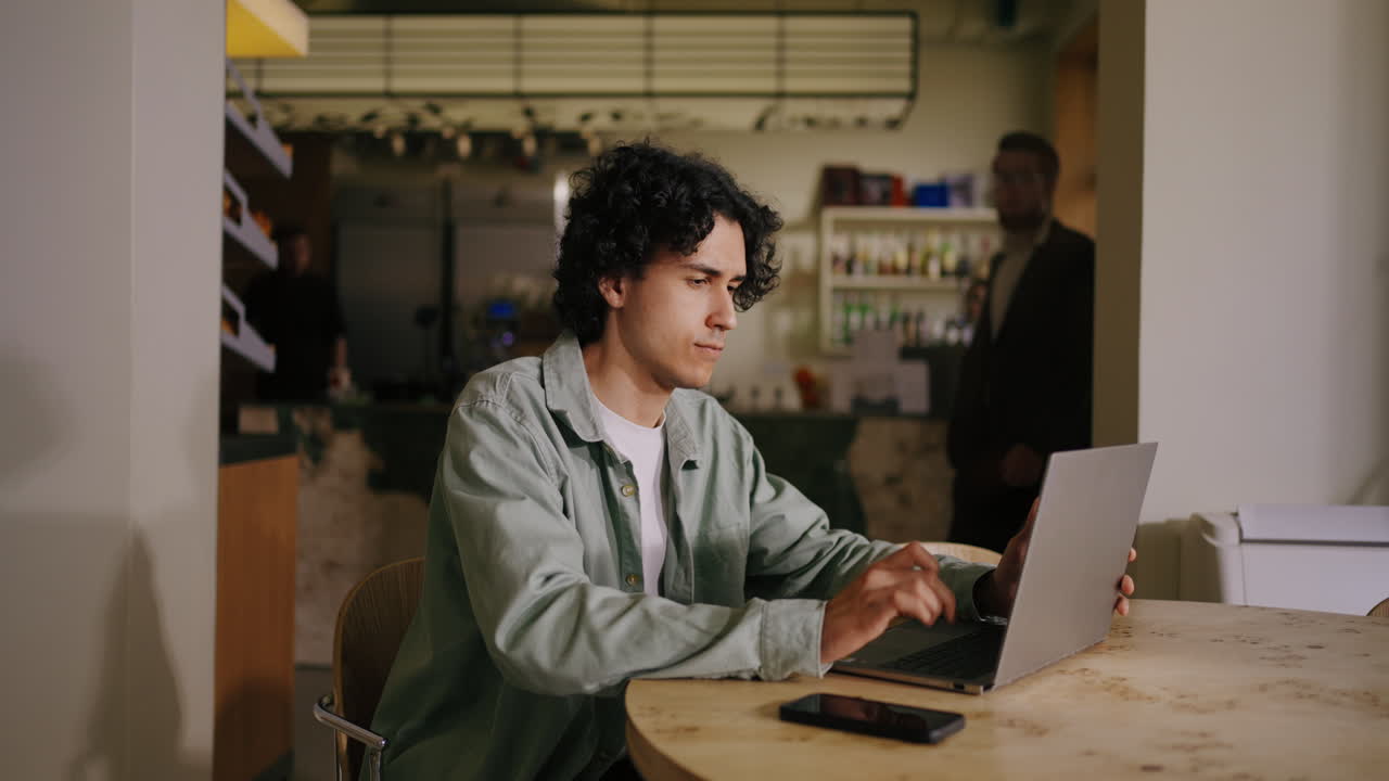 hombre trabajando en una computadora portátil en un café