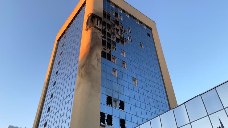 Foguetes bombardearam e destruíram um arranha-céu alto com janelas de vidro quebradas na Rua Solomianska em Kiev, Ucrânia, danos críticos de guerra na capital da cidade, Rússia ataca a Ucrânia, 4K, inclinação para baixo.