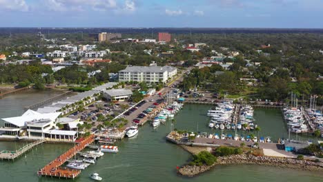 drone footage over downtown dunedin, florida marina with boats and the gulf of mexico and tampa bay