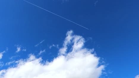 Trail-of-plane-vapour-flying-in-the-blue-sky-through-the-clouds,-Spain