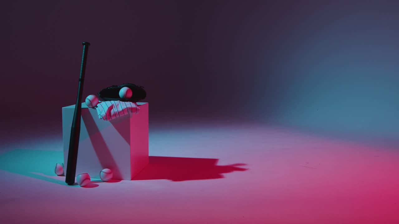 vida muerta de estudio de béisbol con receptores de pelota de murciélago, guantes y camiseta del equipo con iluminación roja y azul 5