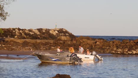 group of people enjoying a boat ride by rocks