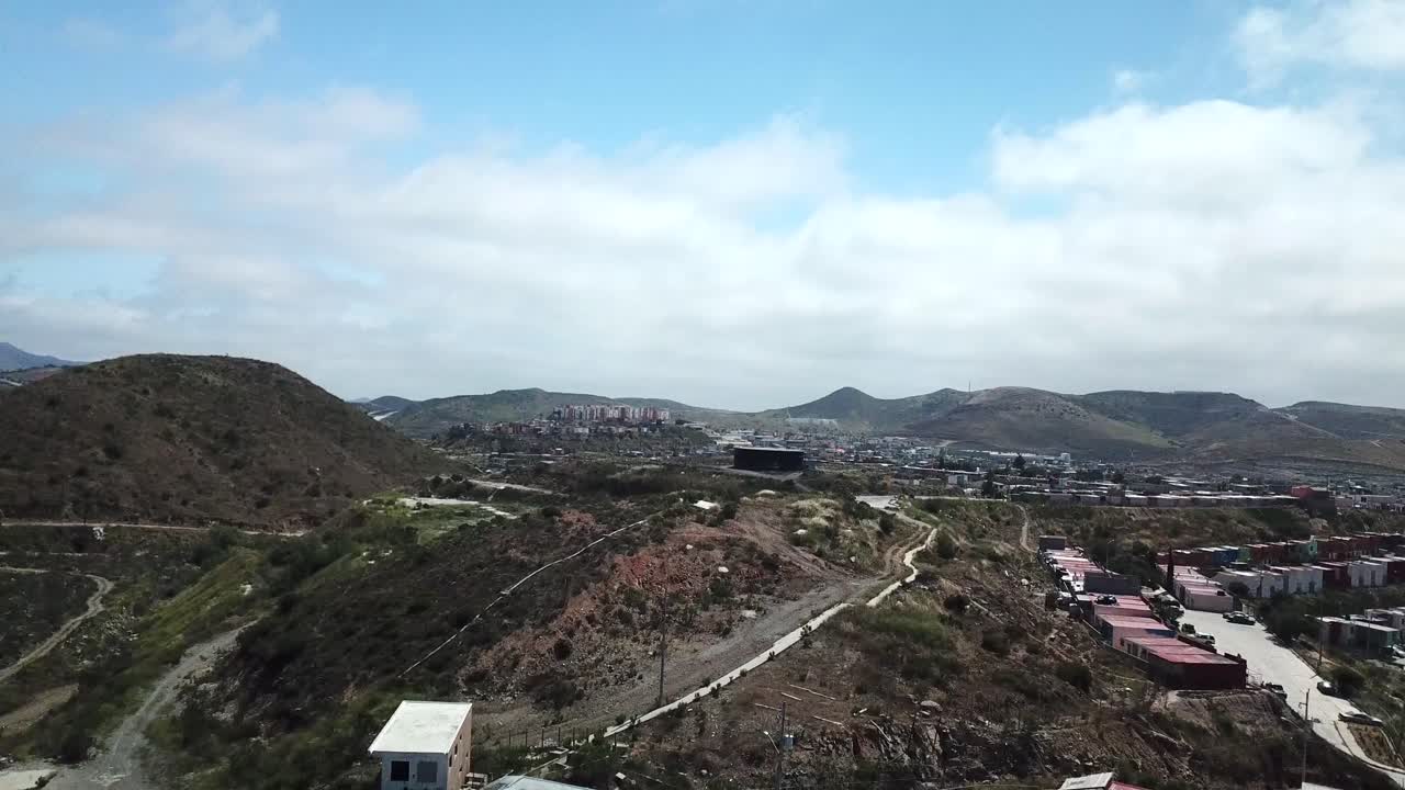 Drone footage of Haciendo Las Delicias, Baja, Mexico in the daytime. Starts up close then cinematically reveals more hillside homes and mountains.