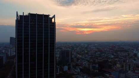 Toma-Aérea-Amanecer-Ciudad-De-México-Paisaje-Edificios-Altos-Cielo-Nublado