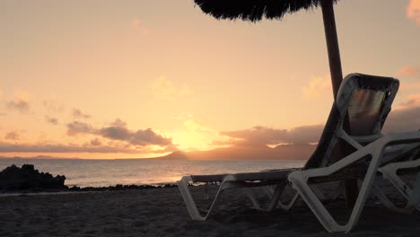 sunset beach scene with lounge chair