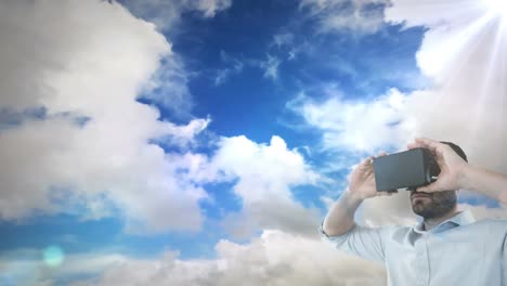 caucasian man wearing vr headset against spot of light and clouds in the sky