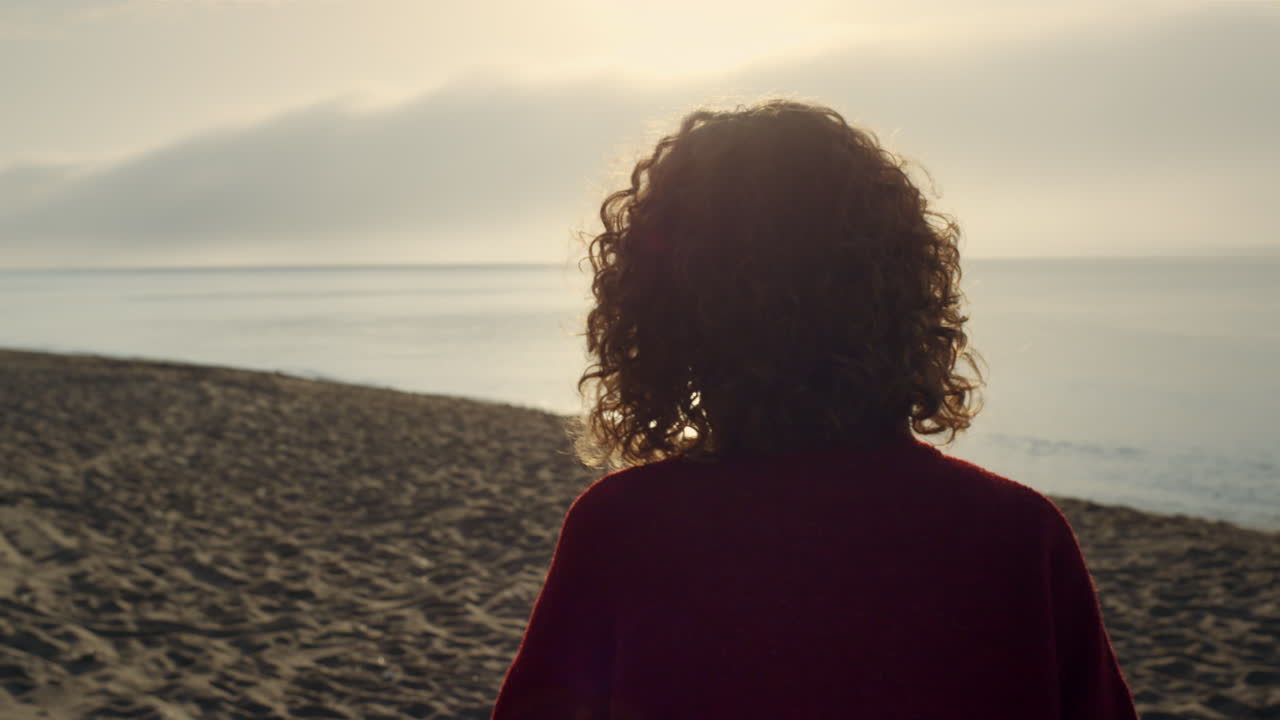 Donna elegante che cammina sulla spiaggia oceanica. Ragazza casual che trascorre il tempo libero al mare.