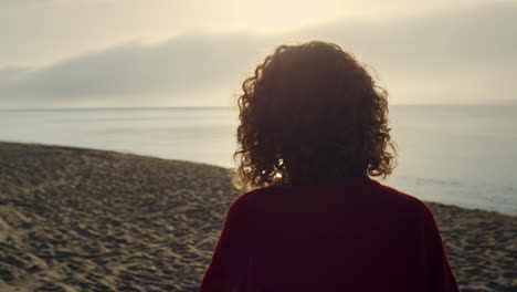 elegant woman walking on ocean beach. casual girl spending leisure time at sea