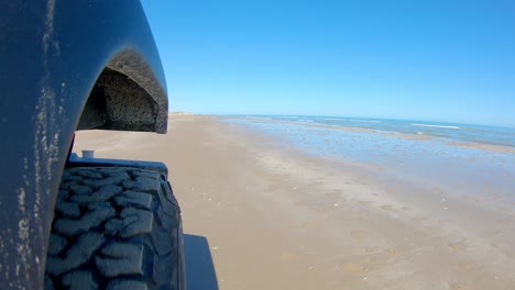 Rechter-Vorderreifen-Des-Fahrzeugs,-Das-An-Einem-Sonnigen-Tag-Auf-South-Padre-Island,-Texas,-An-Einem-Strand-Fährt---Sicht,-Pov