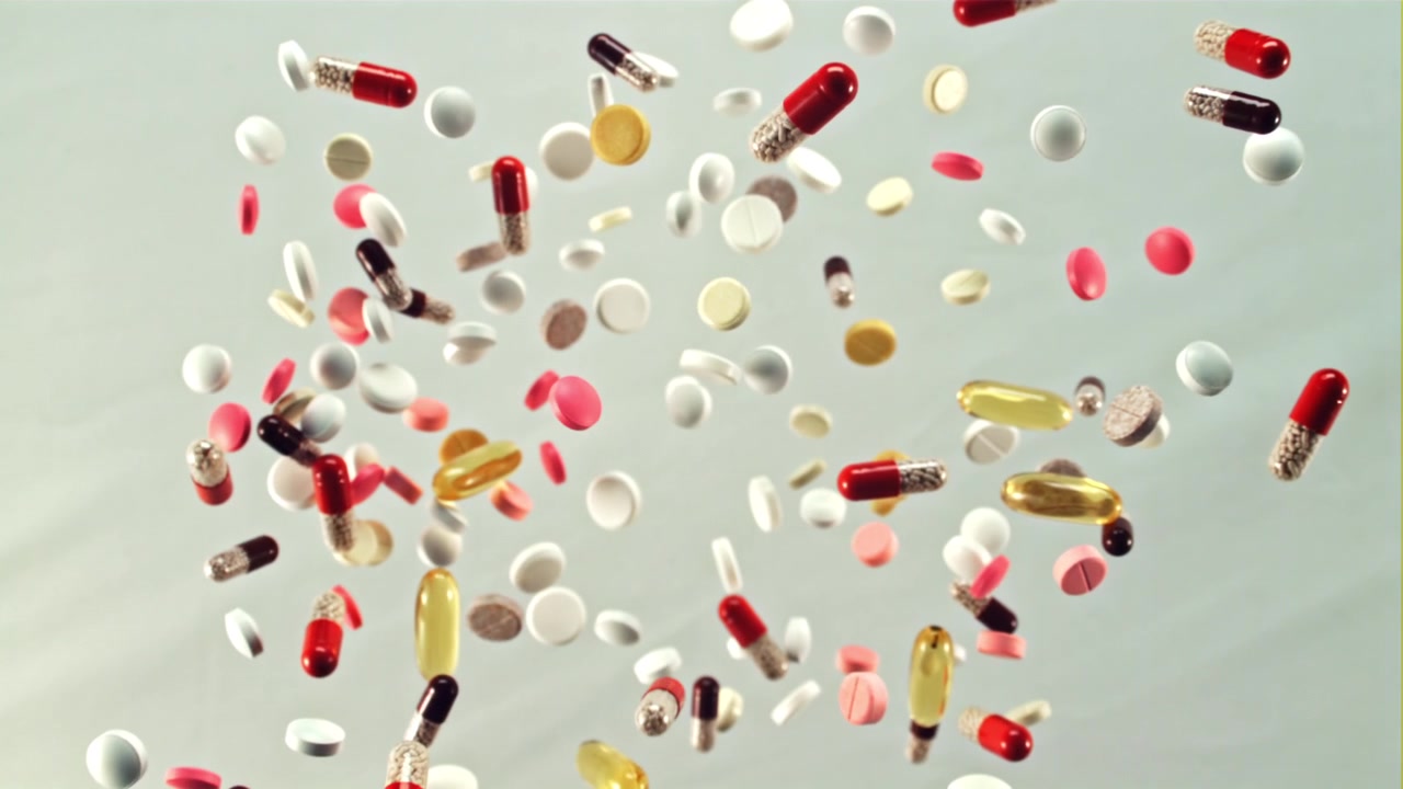 Colorful Pills and Capsules Falling in Slow Motion