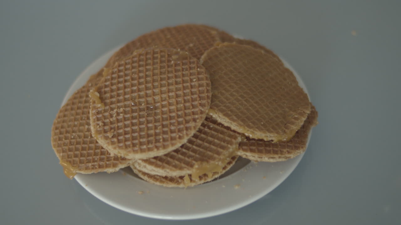 쿠키 더미에서 stroopwafel을 잡는 손의 하향식 보기