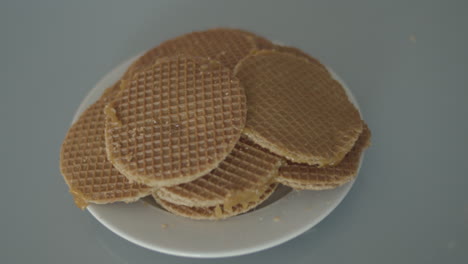 Top-down-view-of-Hand-grabbing-stroopwafel-from-pile-of-cookies