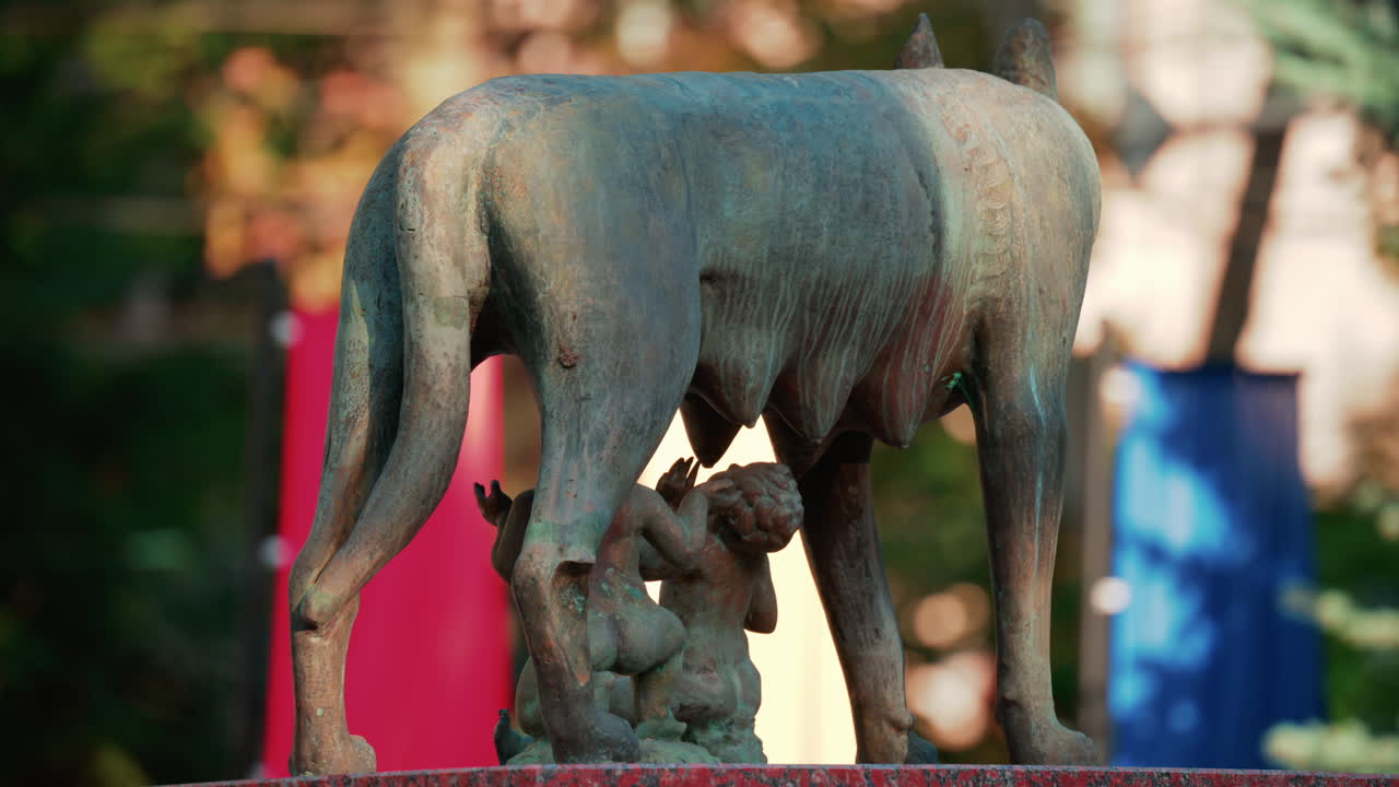 Chisinau, Moldova - September 25, 2025: Historic bronze statue of the Capitoline Wolf with Romulus and Remus on a red marble pedestal in front of the National History Museum of Moldova