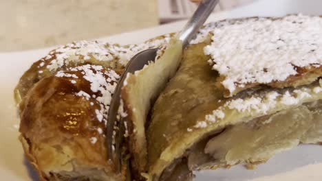 fotografía de cerca de un tenedor cortando un pastel, de mano