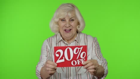 Ältere-Großmutter-Zeigt-20-Prozent-Rabatt-Schild-Und-Freut-Sich-über-Gute-Rabatte-Und-Niedrige-Preise