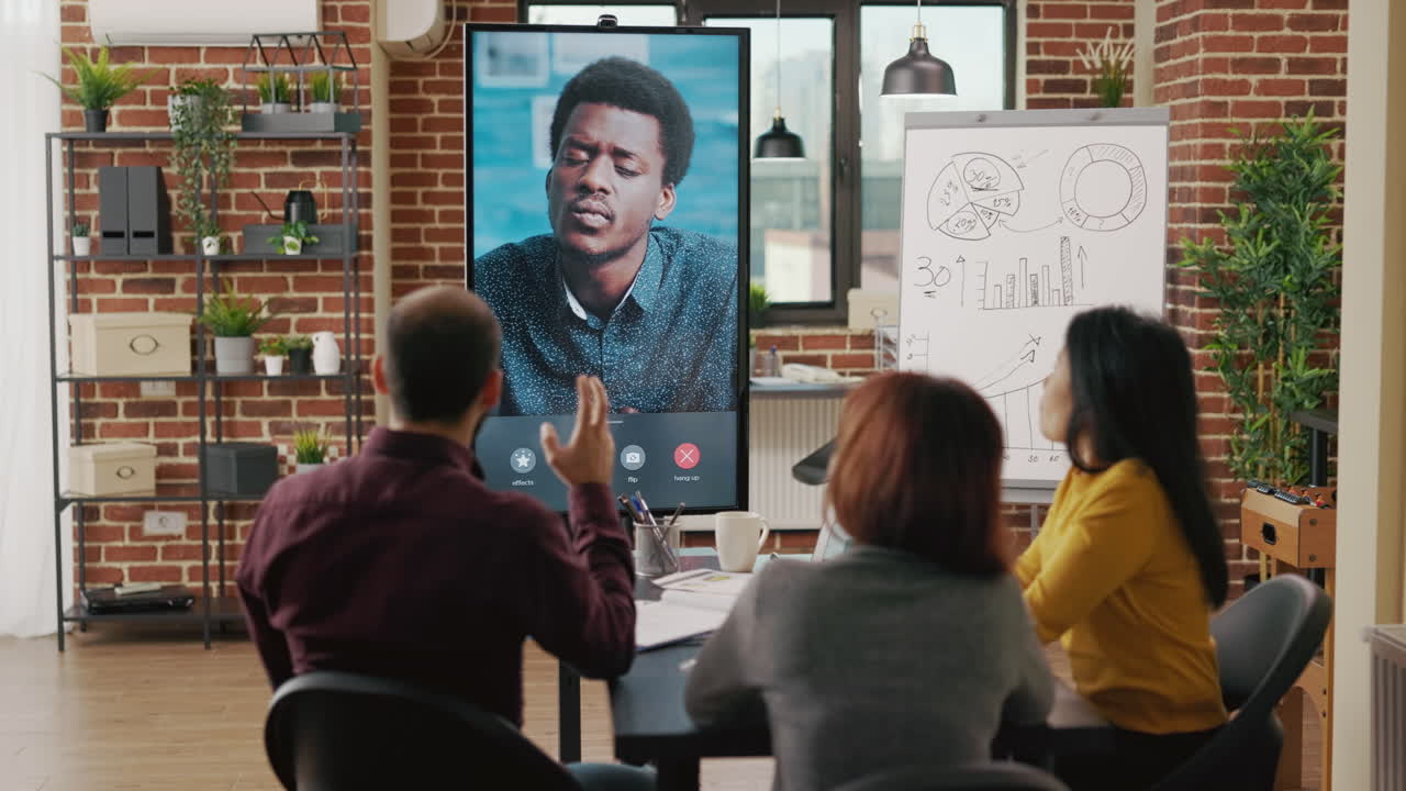 Colleagues meeting with man on video conference