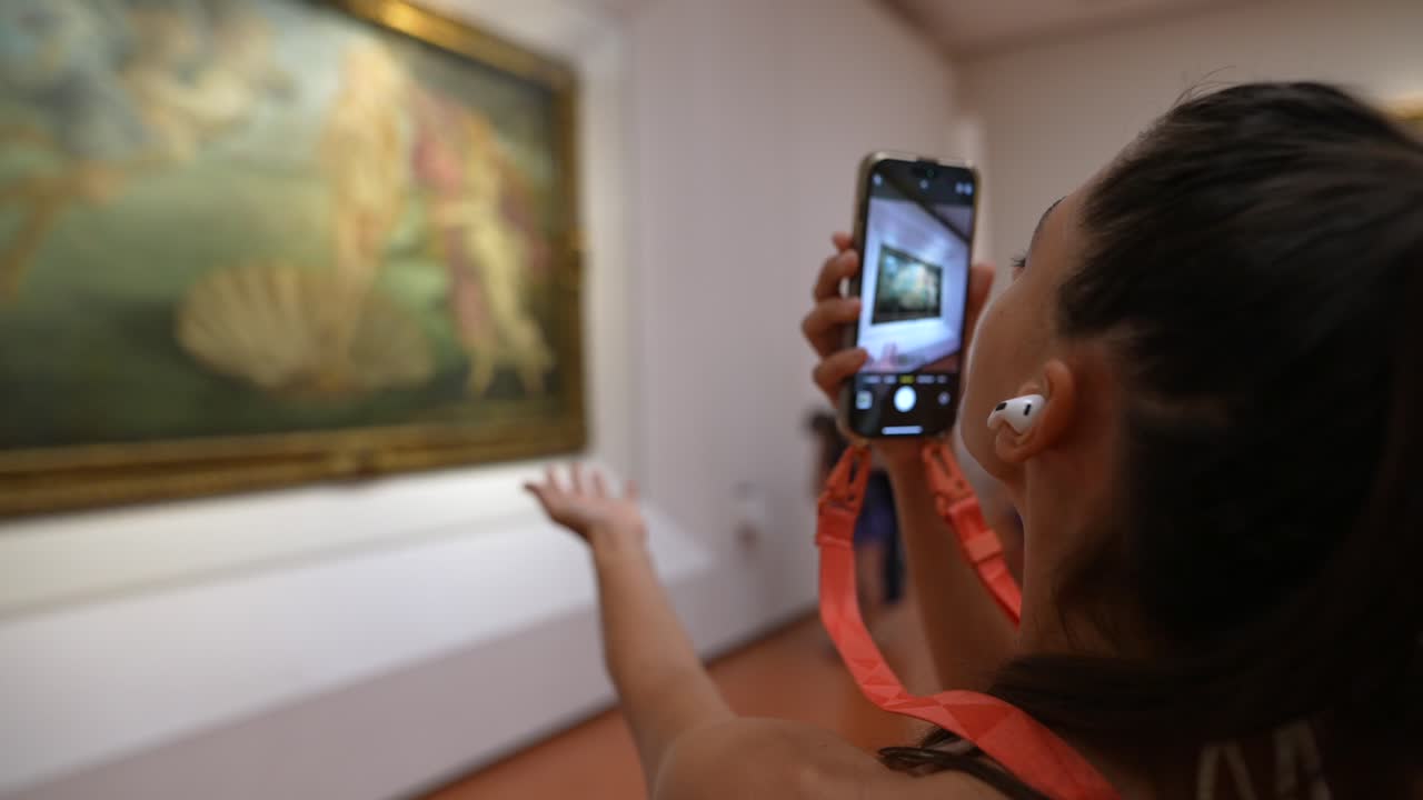 mujer tomando una foto de una pintura en un museo