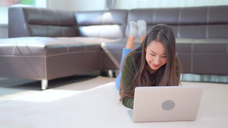 Auf-Dem-Bauch-Liegend-Arbeitet-Eine-Hübsche-Junge-Frau-An-Ihrem-Laptop