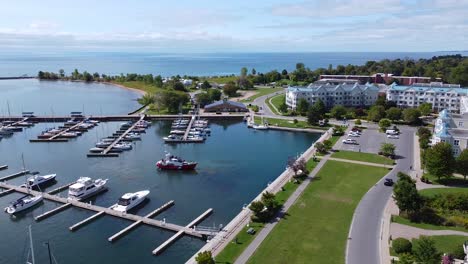 picturesque marina waterfront with housing buildings, people, yachts and sail boats moored at docks