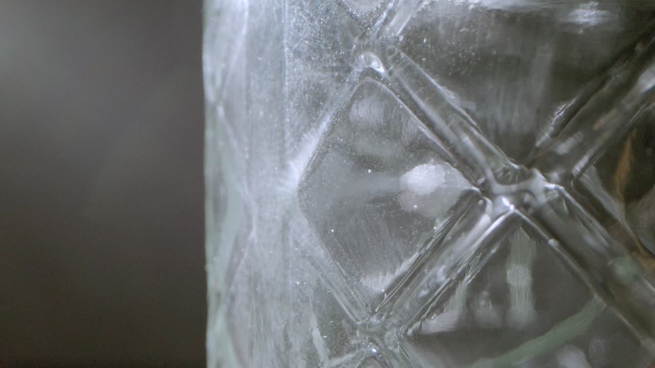 빈 패턴 유리 항아리의 매크로  ⁇ 이 천천히 회전하여 빛을 반사합니다.