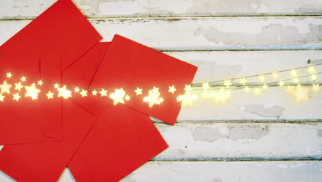 animation of string lights over red envelopes on painted wood boards