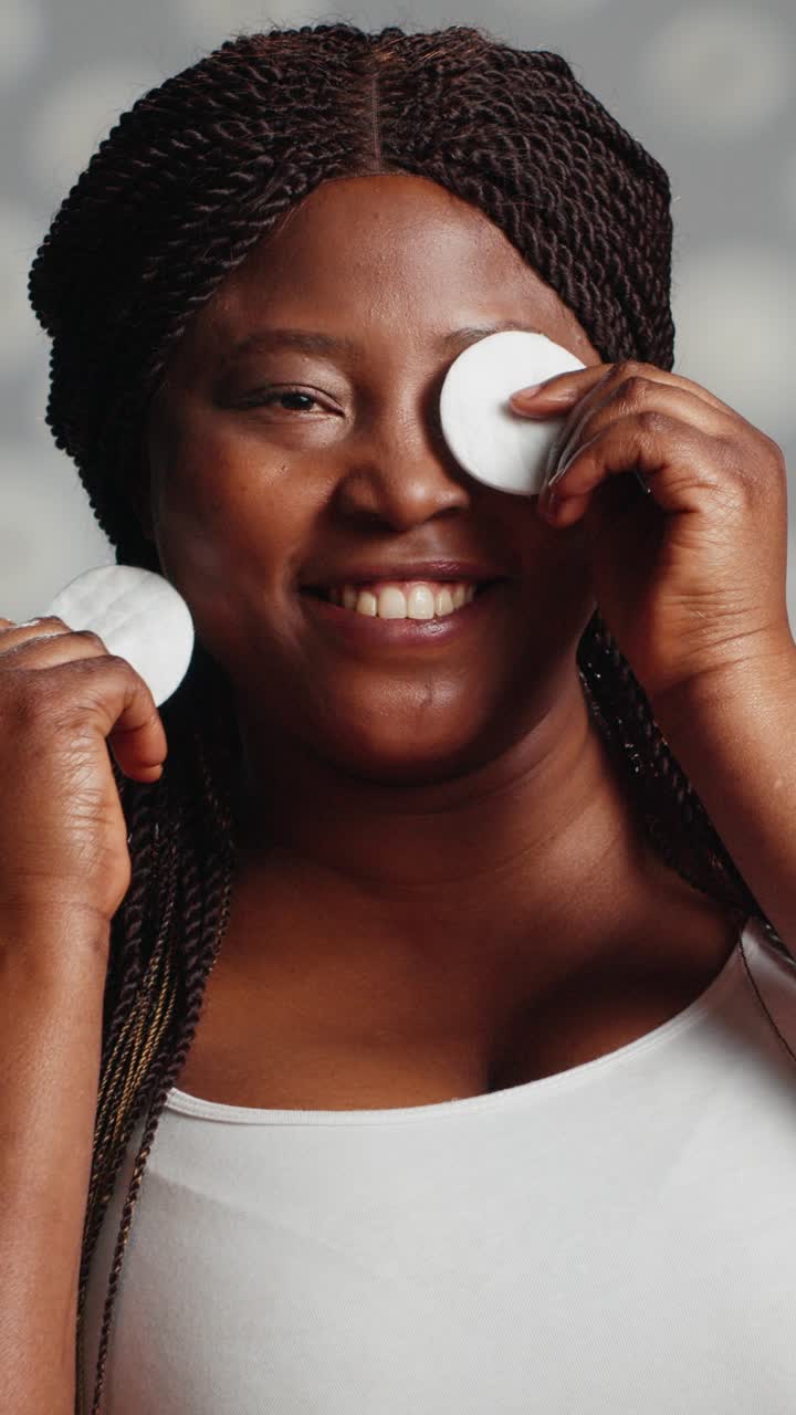 Vertical video: Beauty model advertising skincare routine with cotton pads