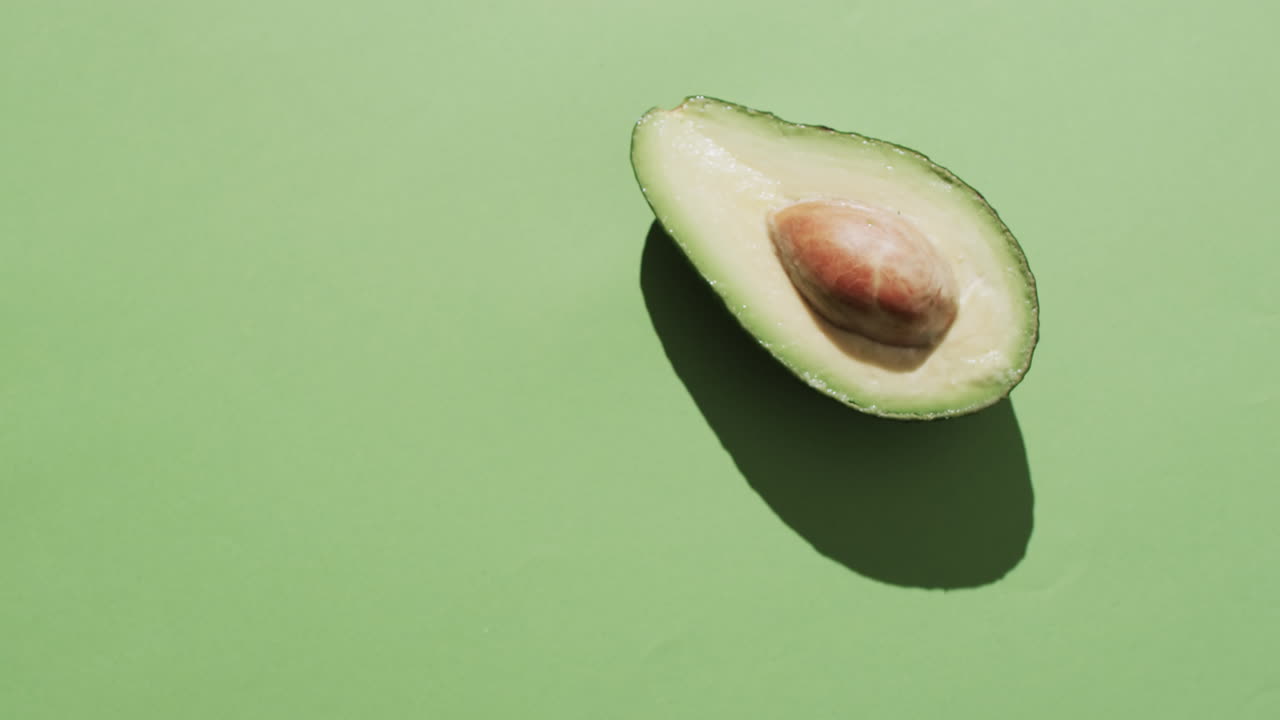 Video di avocado affettato con spazio per il testo su sfondo verde