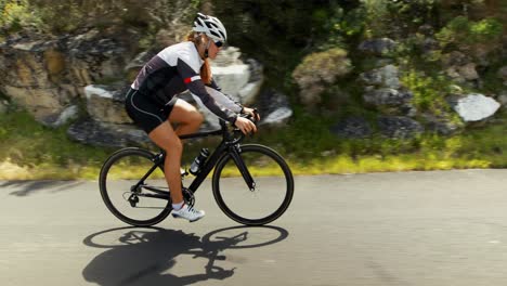 Female-cyclist-cycling-on-a-countryside-road-4k