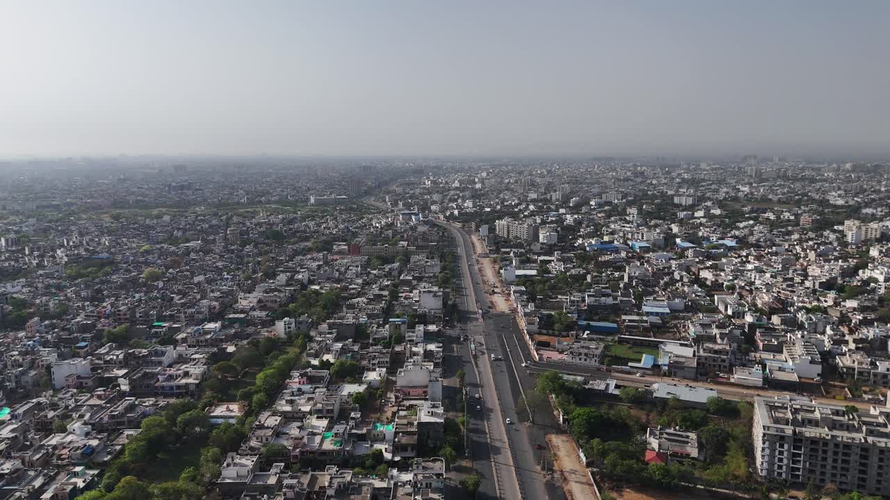 Aerial view of Jaipur's dense cityscape with tightly packed homes and busy streets.