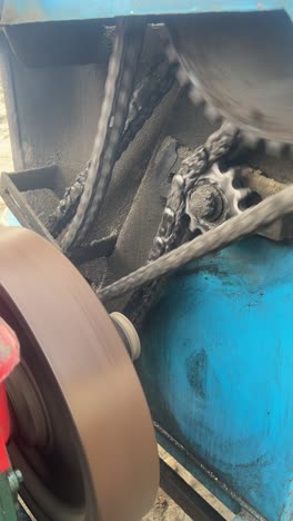 sprockets, gears and chains driving a motor on a industrial construction machine, vertical shot.