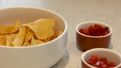 bowl of chips with salsa dipping repeated