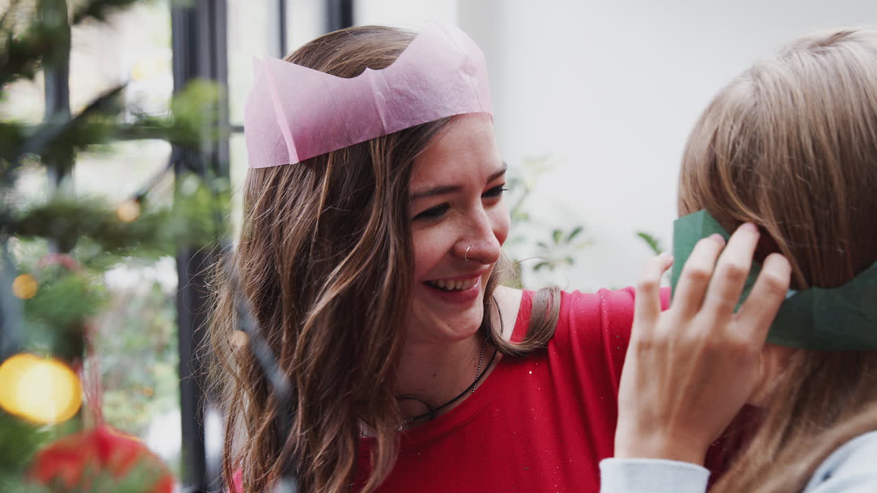 게이 여성 커플 이 집 에서 함께 크리스마스 트리 에 장식 을 매달고 재미 를 느끼고 있다