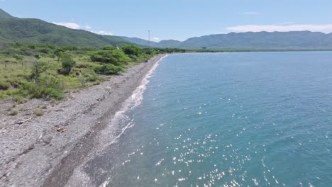 Aerial-flyover-rocky-beach-with-Ocoa-Bay-in-Azua