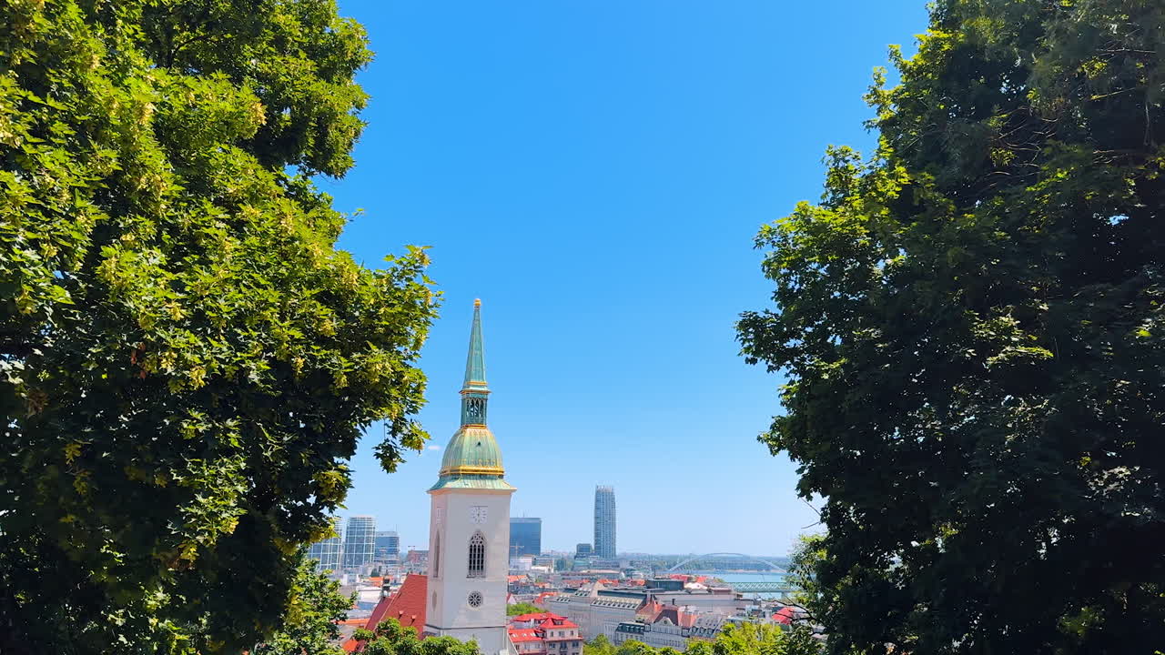 White Tower of St. Martin's Cathedral with a clock among the greenery of trees. Old architecture of Bratislava, Slovakia