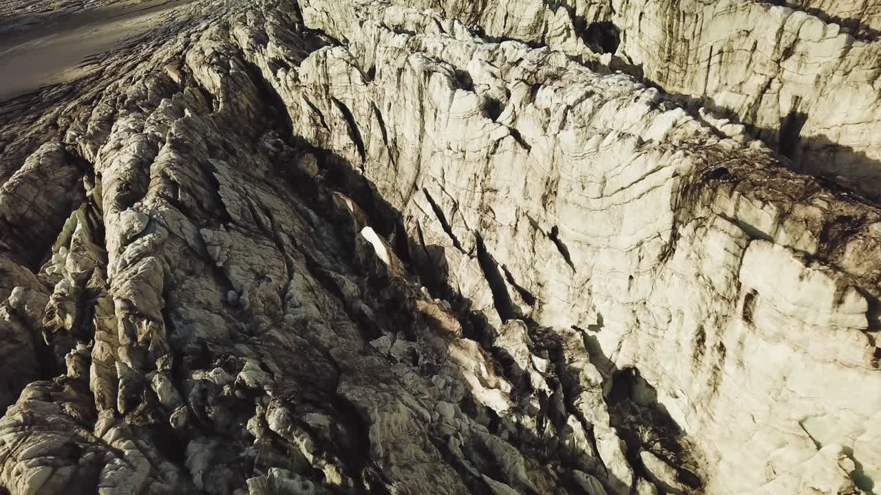 vista aérea desde arriba sobre la superficie de hielo texturizada de un glaciar islandés, al anochecer