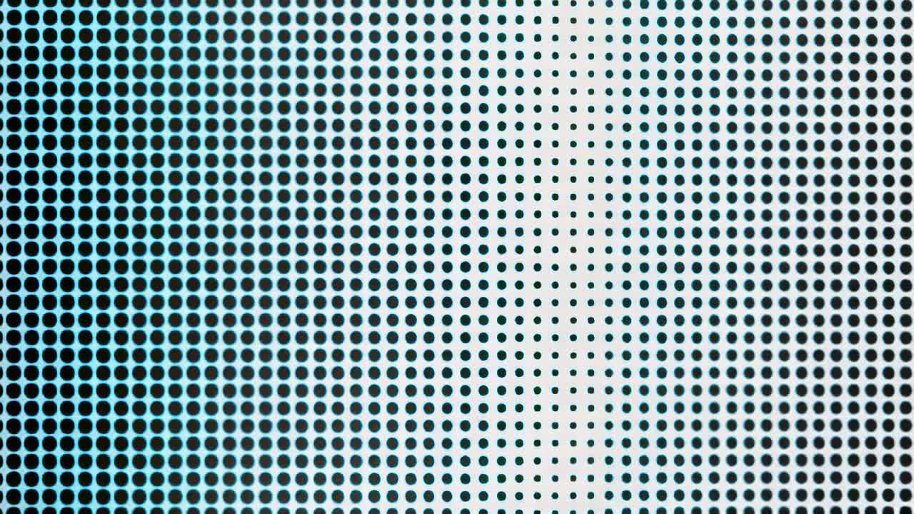 Appearing cyan band shifting across dot grid in macro under cyan backlight, fading black dots