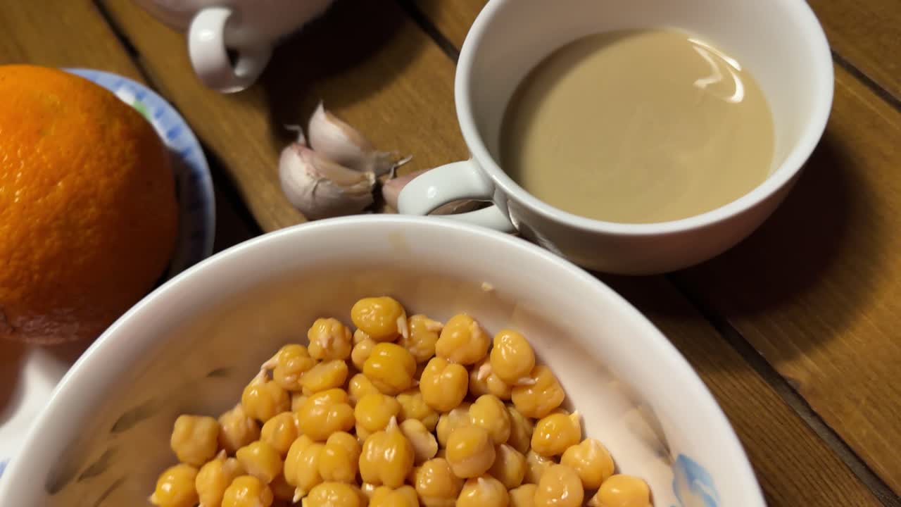 Ingrediente per cucinare: mix di hummus, salsa, aglio, limone, ceci e consistenza cremosa in ciotola. Cucina mediterranea, sano, fatto in casa, guarnizione con olio d'oliva, gustoso, tradizionale, vegano, vegetariano, piatto turco-libanese.