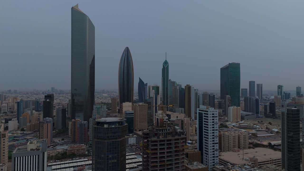 Drone 4K shot of Kuwait City skyline showing modern high-rises and dense architecture. Ideal for themes on urban growth, Middle East development, construction, and real estate visuals.