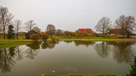 Clip-De-Fusión-De-Casas-Junto-Al-Lago-En-Un-Hermoso-Paisaje-Otoñal,-Con-Casas-Rodeadas-De-Una-Lujosa-Vegetación-Verde