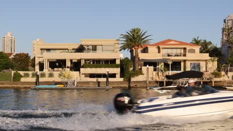 speedboat cruising by upscale riverside properties