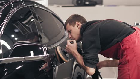 hombre lustrando un coche negro nuevo.