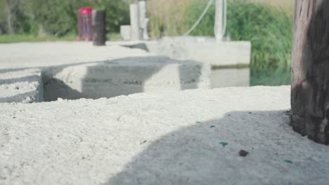 un par de zapatillas negras en concreto junto al agua
