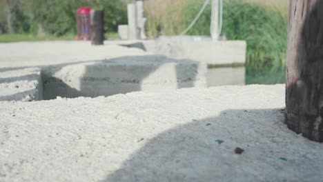 pair of black sneakers on concrete next to water