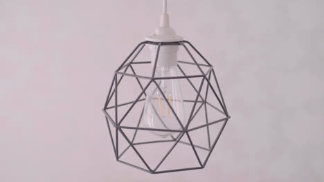 geometric lamp shade bulb turning off closeup