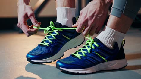 close-up video of hands tying neon-laced running shoes, capturing the action from a low angle