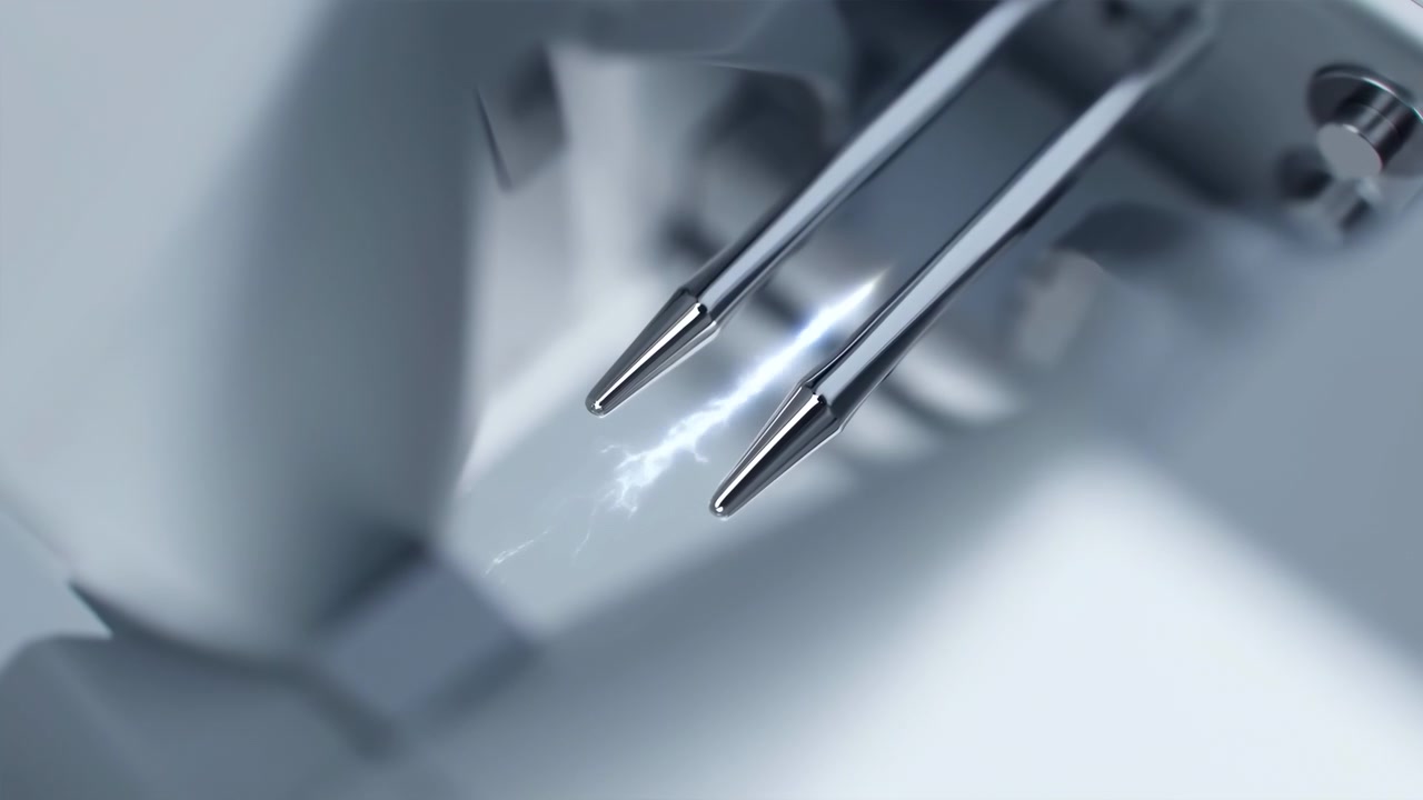 Two polished stainless steel probe tips move inward in close macro view, holding parallel alignment while small bright spark flashes between shafts, creating precise scientific metallic detail